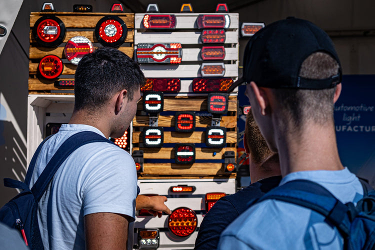 Customers looking at a light board display of RoadLites led contour outline lights and marker lights.