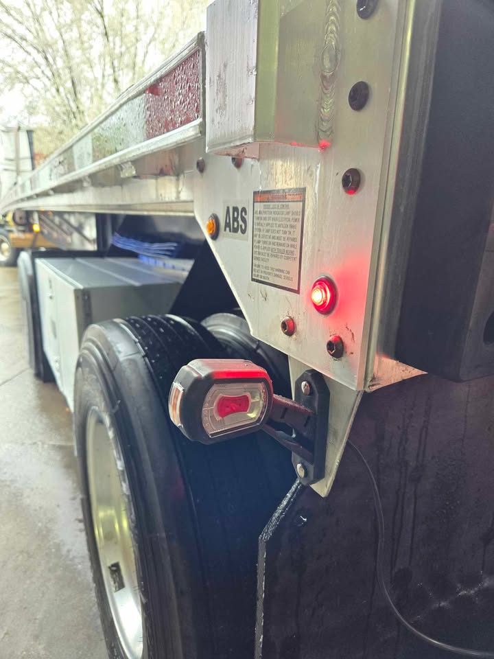 High-visibility red led outline marker light for enhanced safety installed on flatbed trailer.