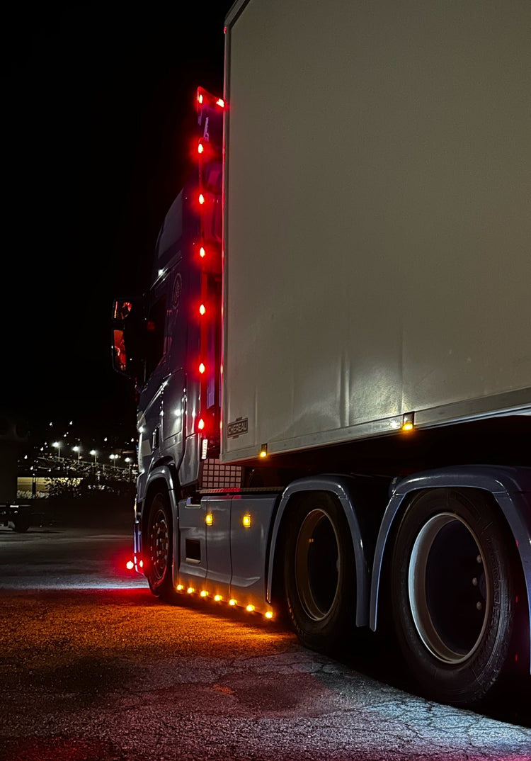 Semitruck lit up in the dark with marker & clearance lights