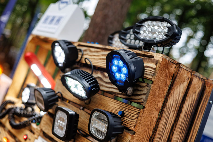Display of RoadLites Raptor series LED work lights on a wooden pallet glowing