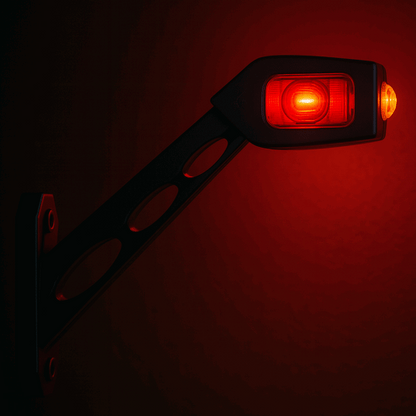 Red LED marker light on a black bracket against a red background