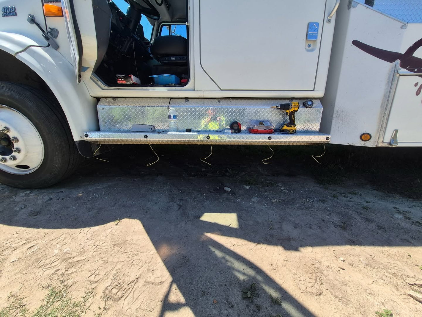 Close up of white Tow Truck getting RoadLites amber marker lights installed.