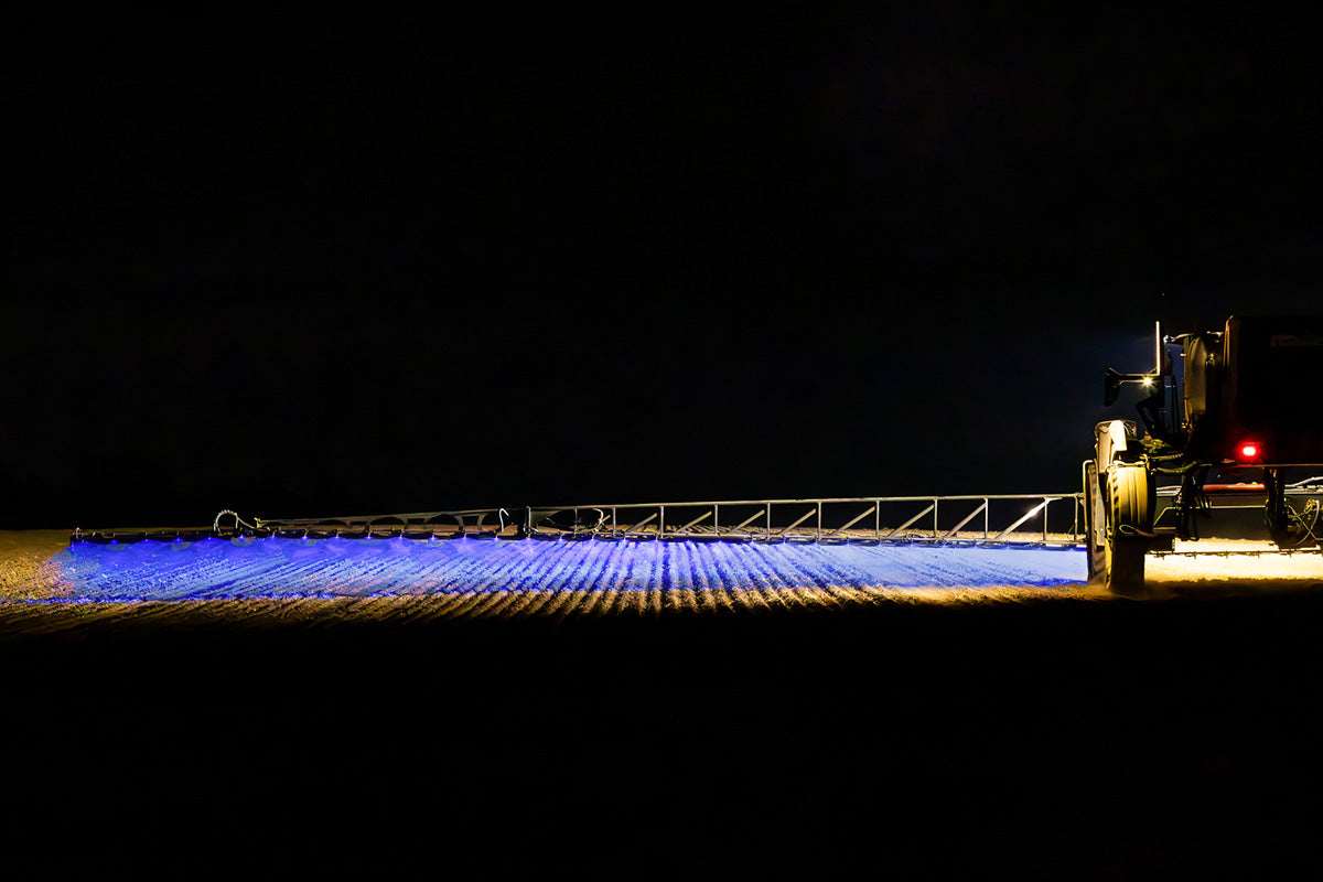 Work light BLUE SPOT RAPTOR (focused light, 400 lm) LRD 3183 illuminating wide agricultural field during nighttime operation