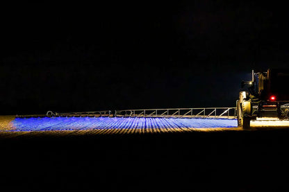 Work light BLUE SPOT RAPTOR (focused light, 400 lm) LRD 3183 illuminating wide agricultural field during nighttime operation